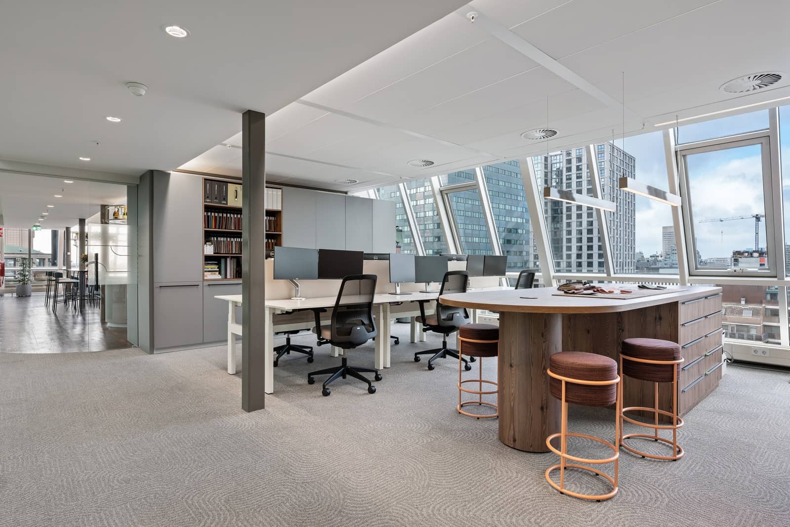 Colliers Rotterdam: open werkplekken met houten statafel en koperen krukken