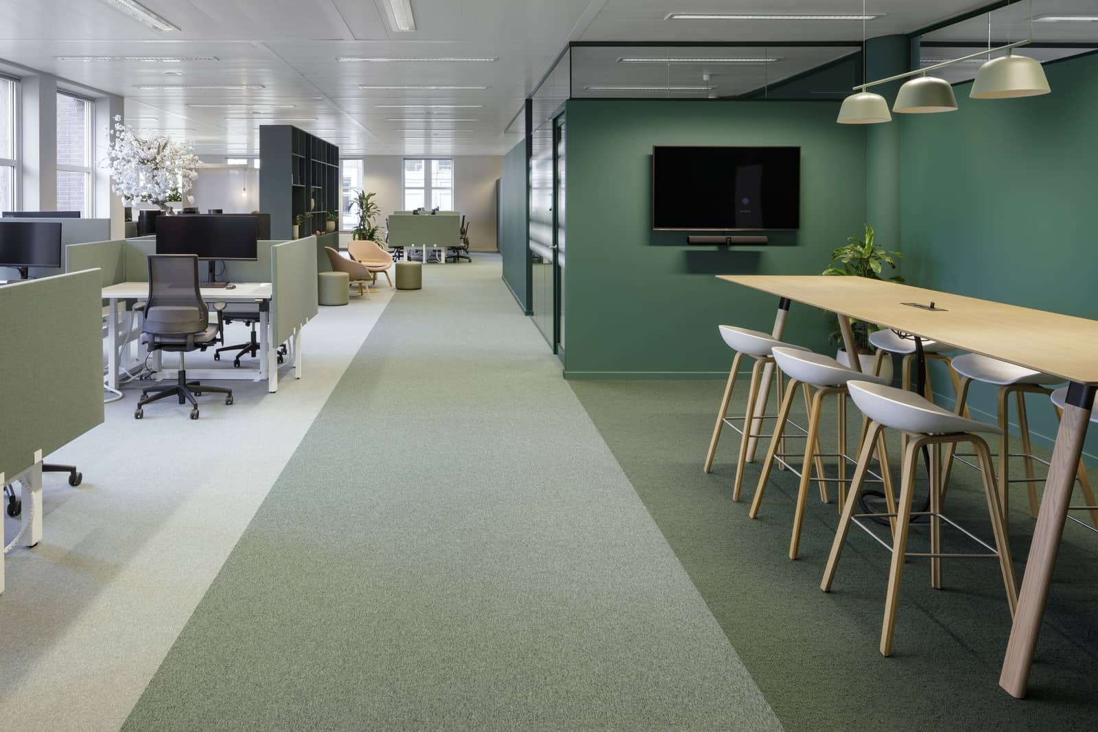 Cygnific Amsterdam: werkzone in groene tinten met hoge tafel en krukken